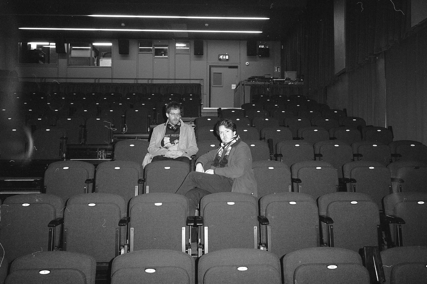 Two people sitting in an empty cinema