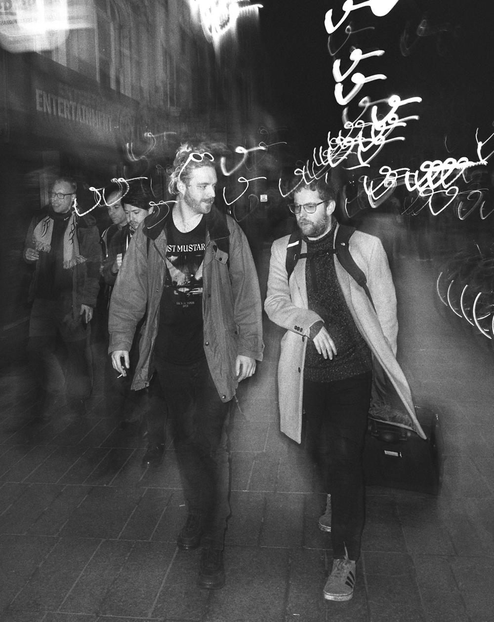 A blurry photo of people walking and talking on a street