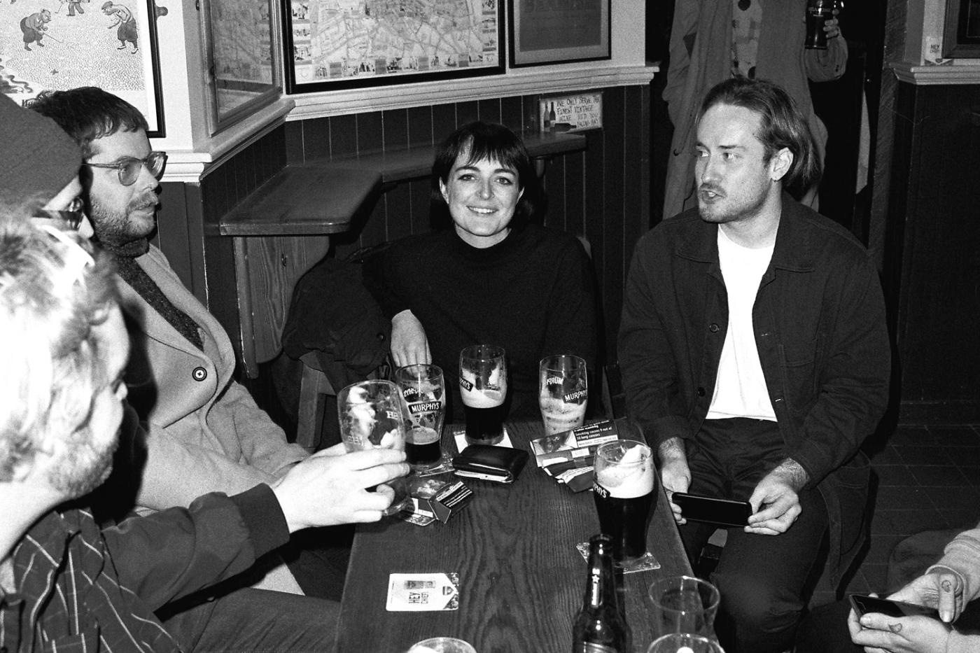 People sitting and chatting around a small table in a bar