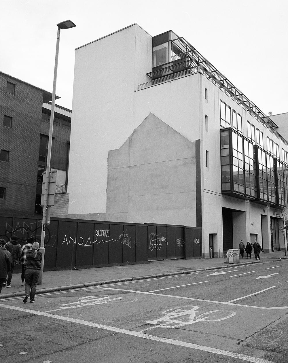The side of a building beside the site of a recently demolished building